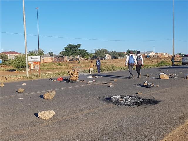 Angry community members barricade road | News Article